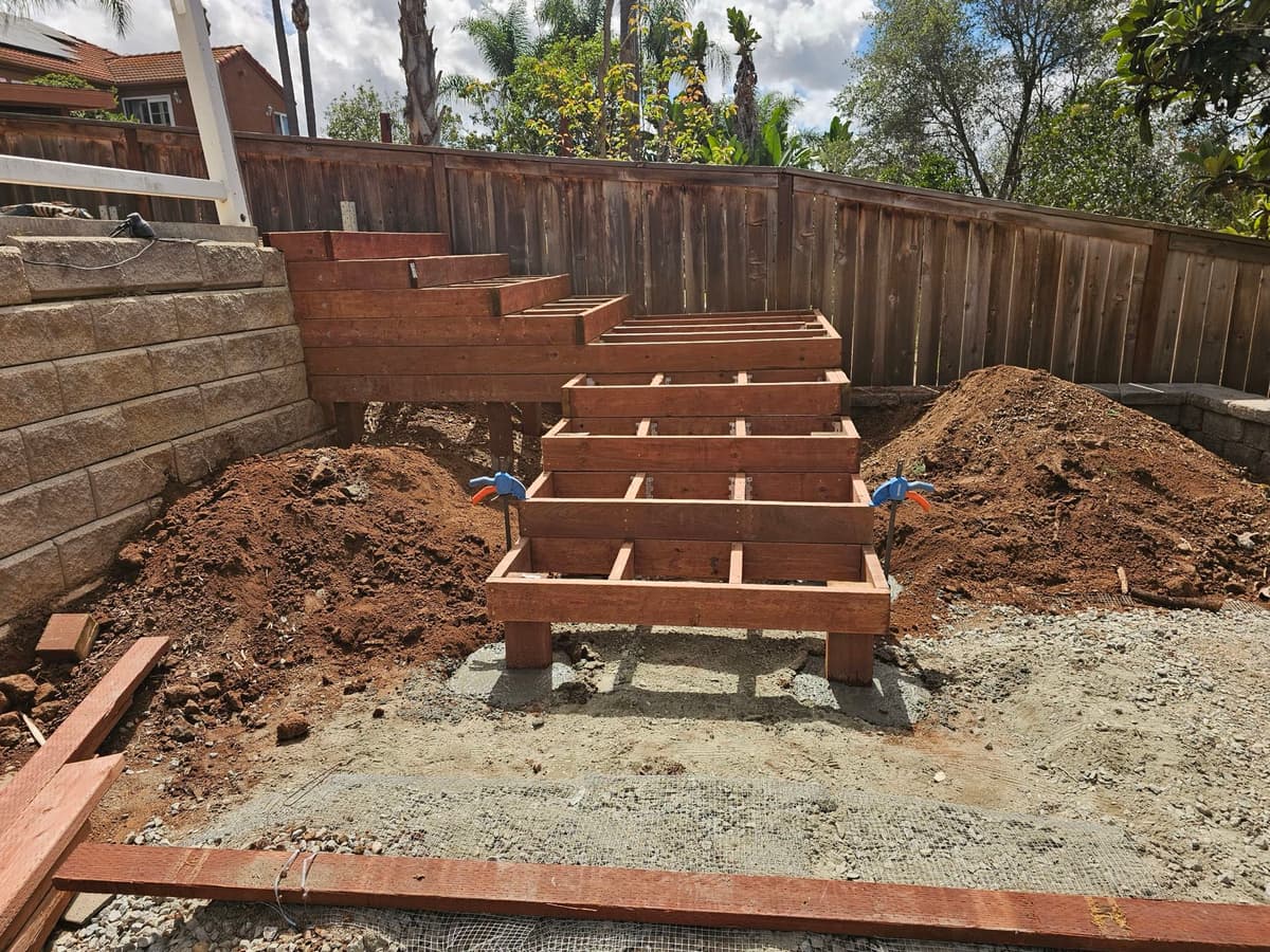 custom wood deck framing under construction against a retaining wall in Stockton, California