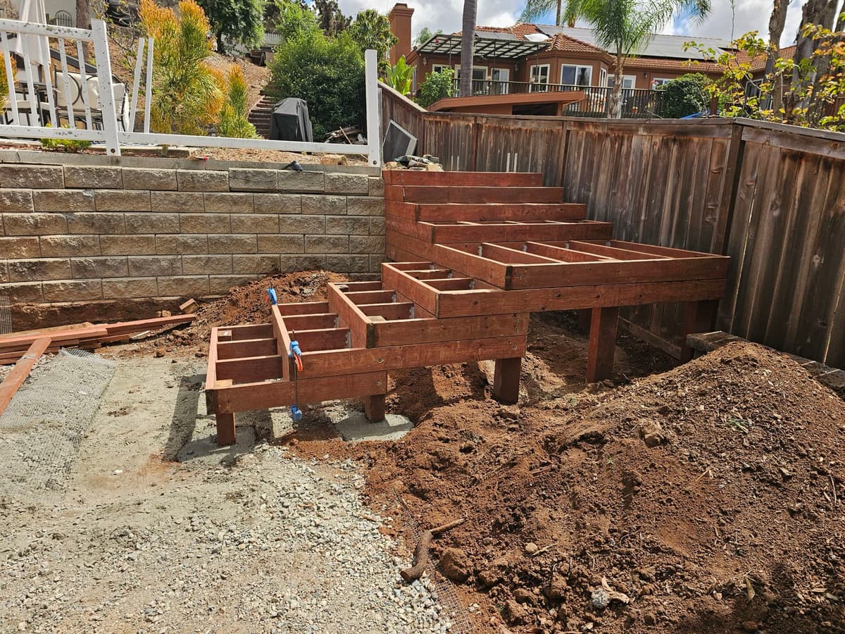 elevated wood deck substructure framing built out from a retaining wall in a hillside backyard in Stockton, California