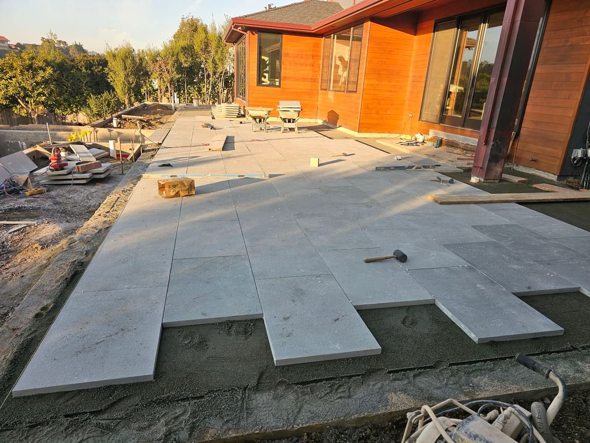 large-format pavers being laid on a sand base during a patio installation at a modern home in Stockton, California