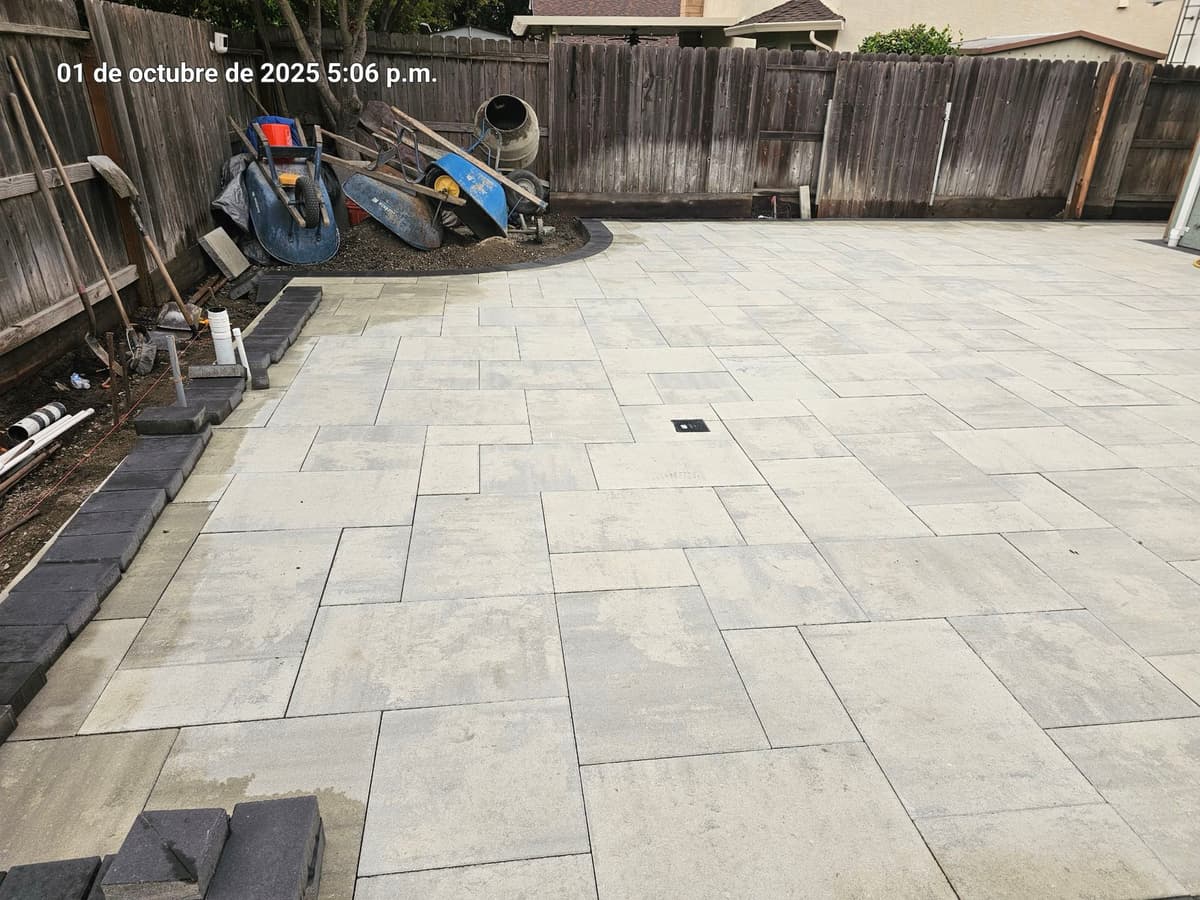wide-angle view of a large paver backyard patio with charcoal border edging in Stockton, California