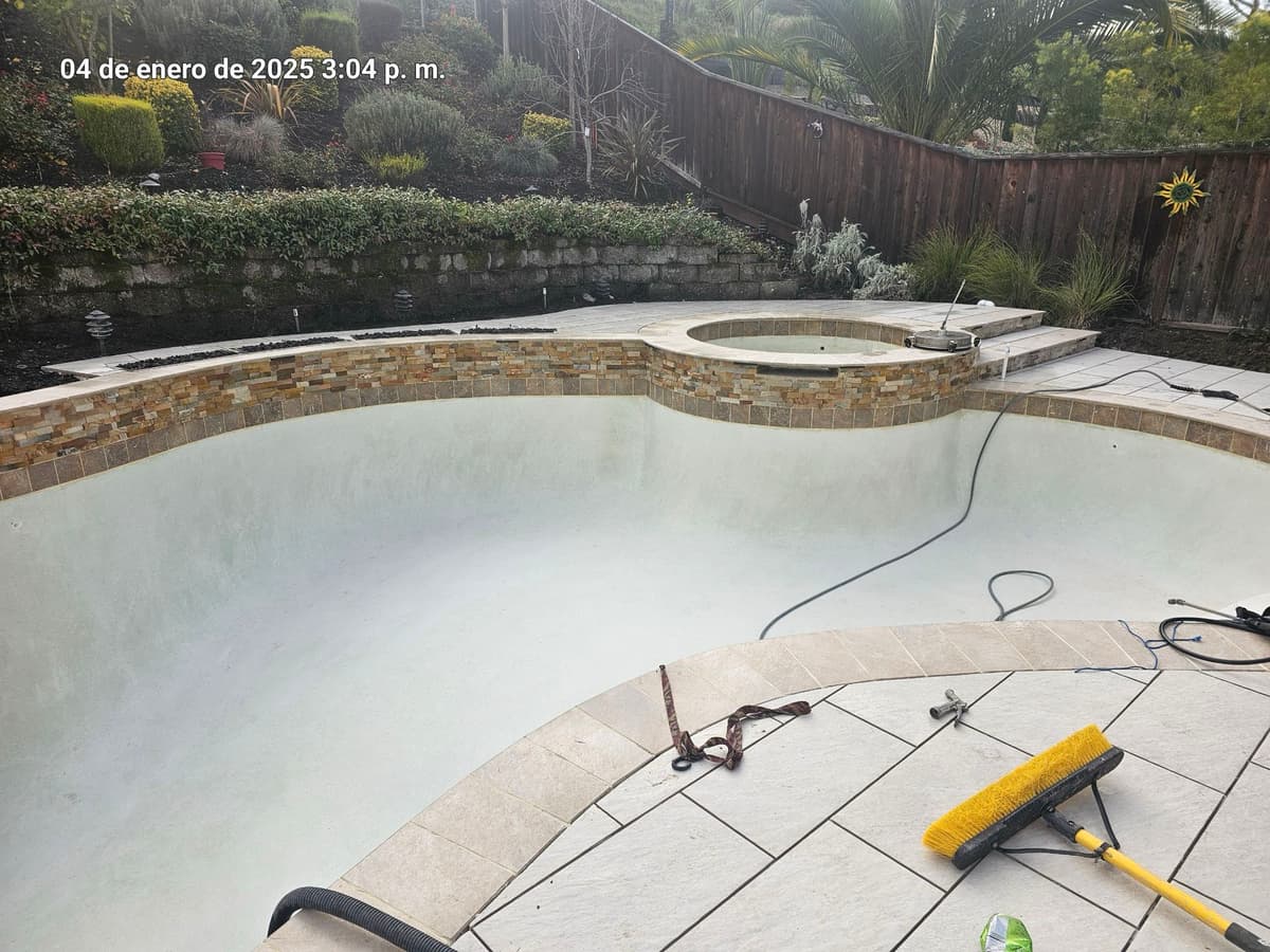 drained pool renovation in progress with a raised spa and stacked stone veneer surround in Stockton, California