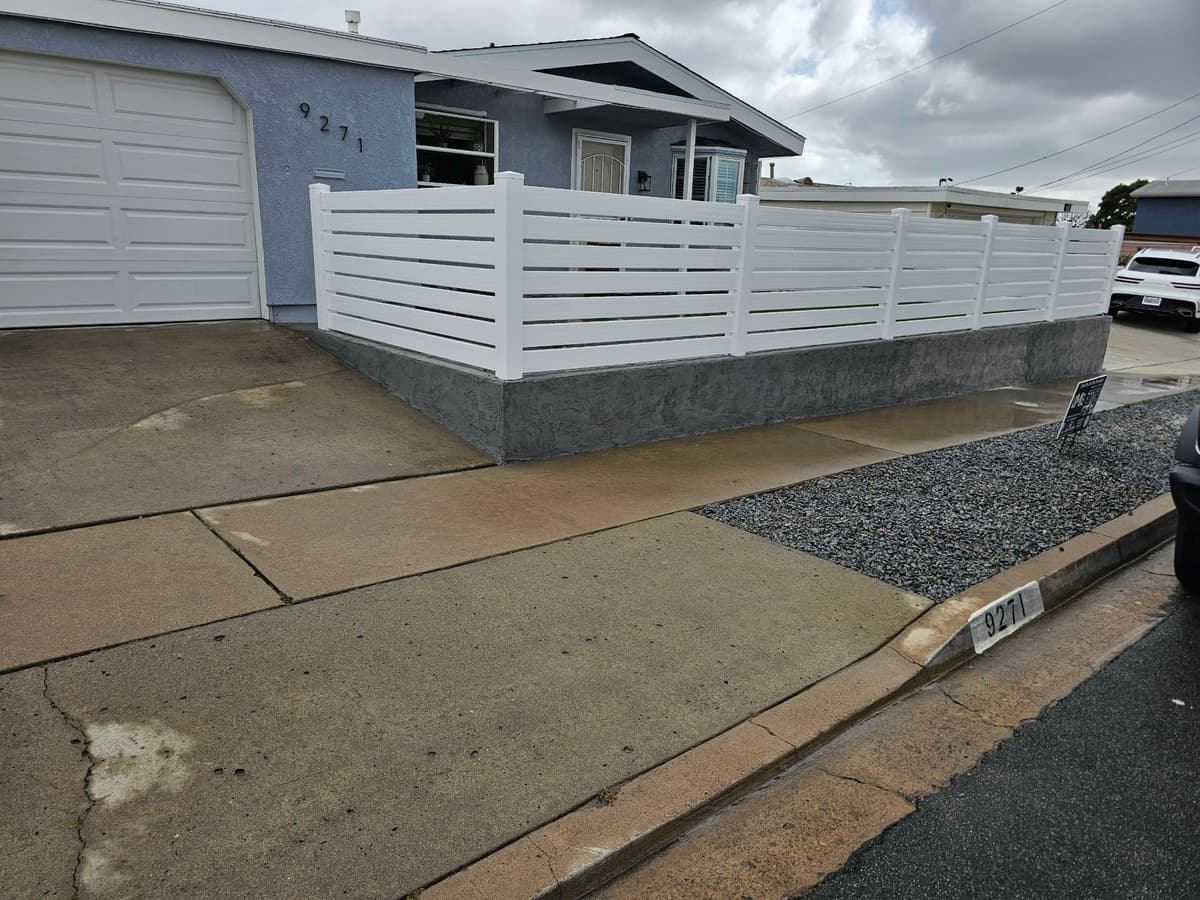 finished white vinyl horizontal-slat privacy fence along a driveway in Stockton, California